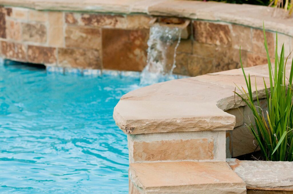 Close-up of a stone-accented pool with a small waterfall feature