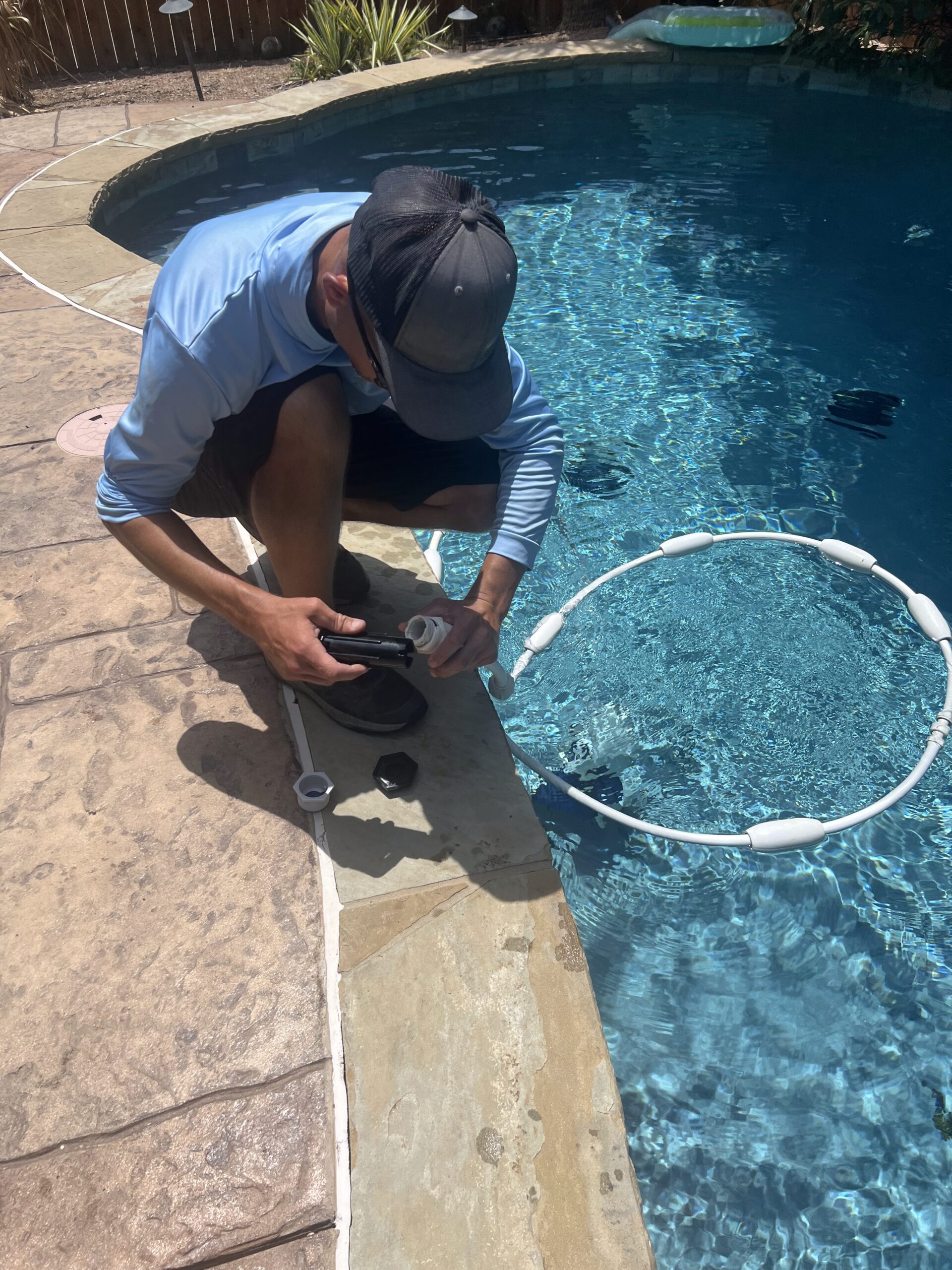 a pool cleaner crouched down by pool